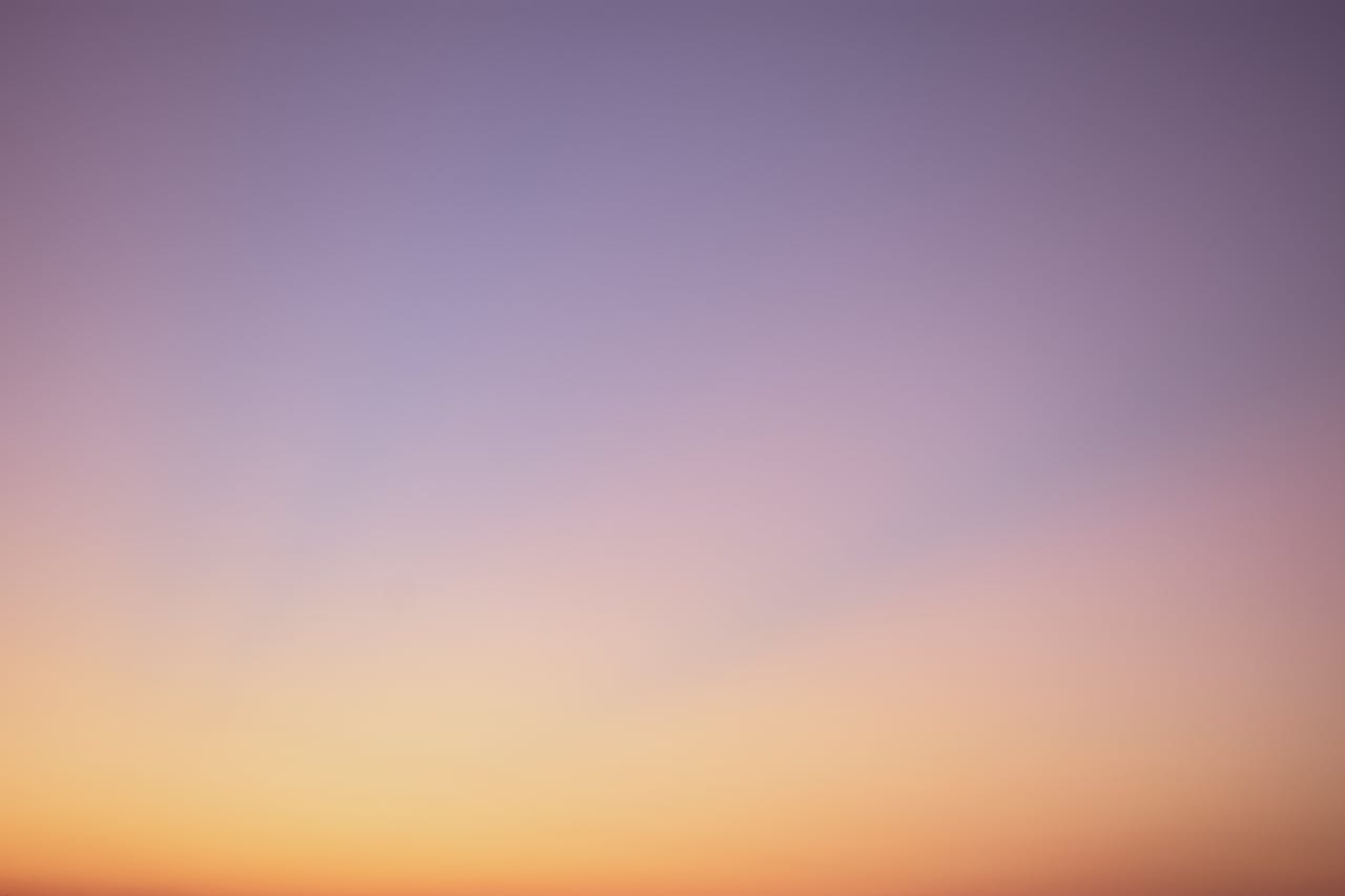 A serene gradient sky with hues of blue, pink, and orange during twilight.